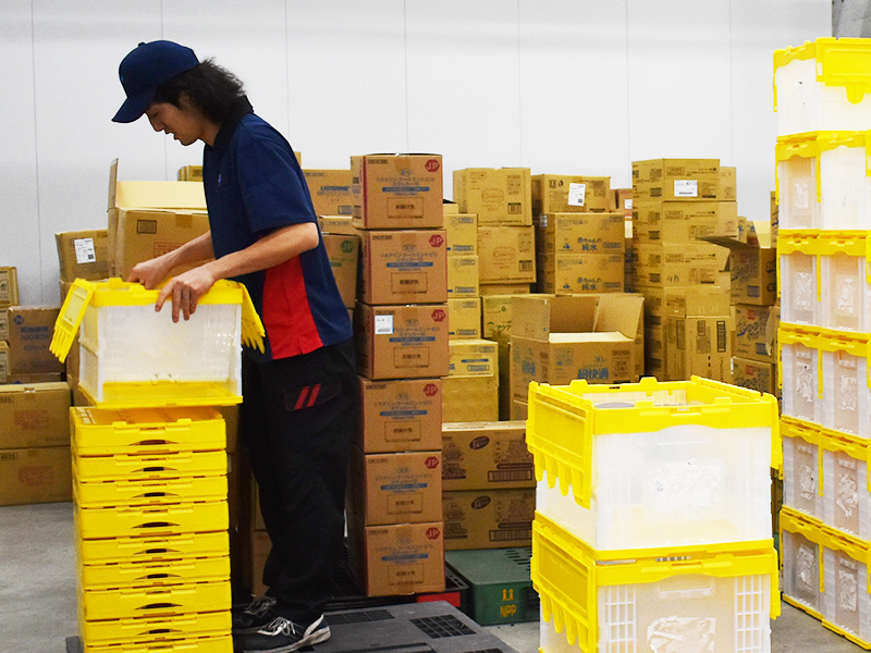 共同配送の現場で荷物を仕分けるスタッフ